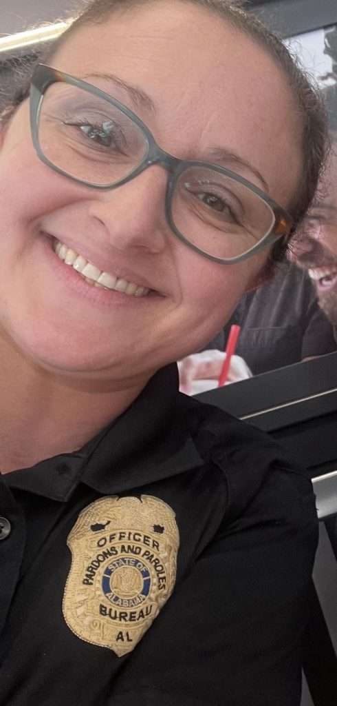 Whitney Maholovich wearing an Alabama Pardons and Paroles Bureau officer badge on a black uniform polo