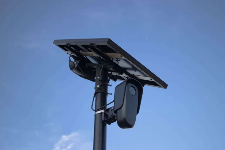 Solar-powered surveillance camera mounted on a pole against a clear sky
