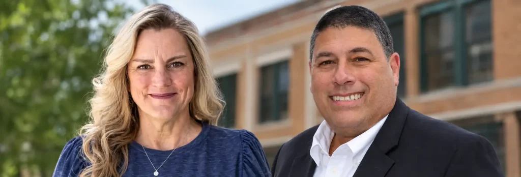 Heather Higgins (left) and Jacob Horwitz (right) of Installation & Service Technologies, standing outside a brick building