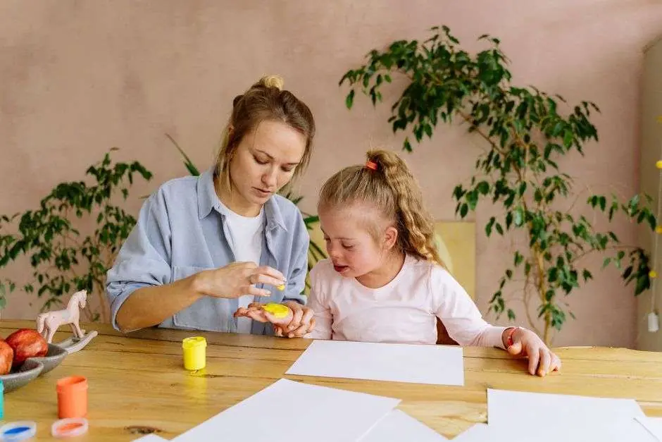 A caregiver reviewing paperwork at a kitchen table with a child nearby
