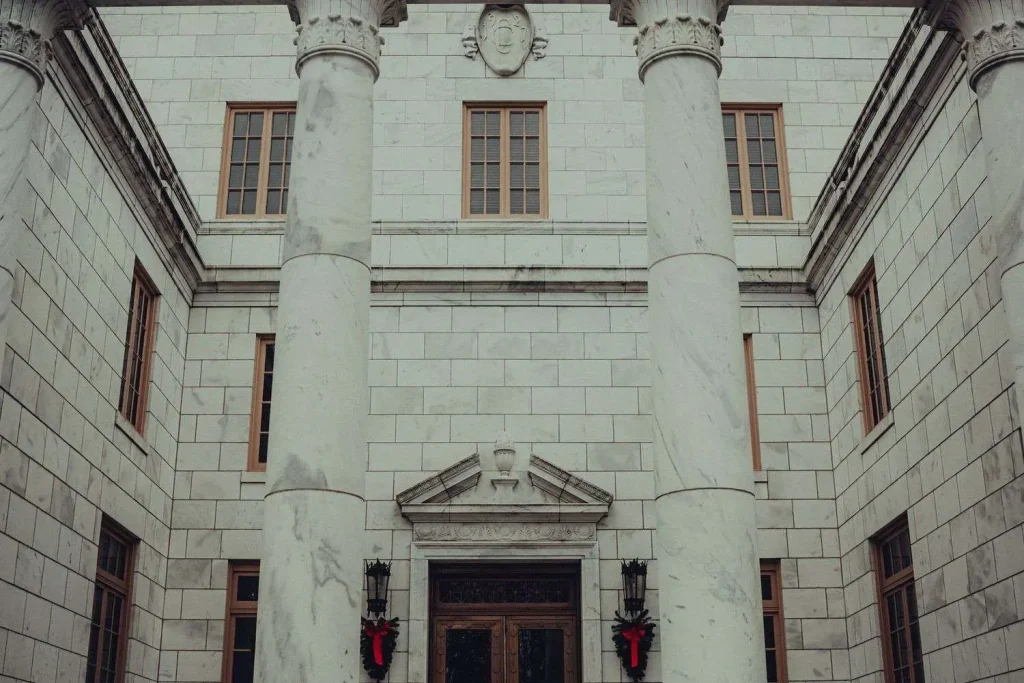 Exterior of a marble courthouse-style building with tall columns and a decorated entrance