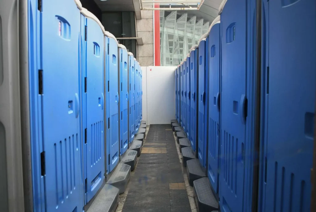 Row of portable toilets lined up outdoors for an event