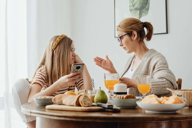 A parent and teenager sitting together in a supportive conversation at home