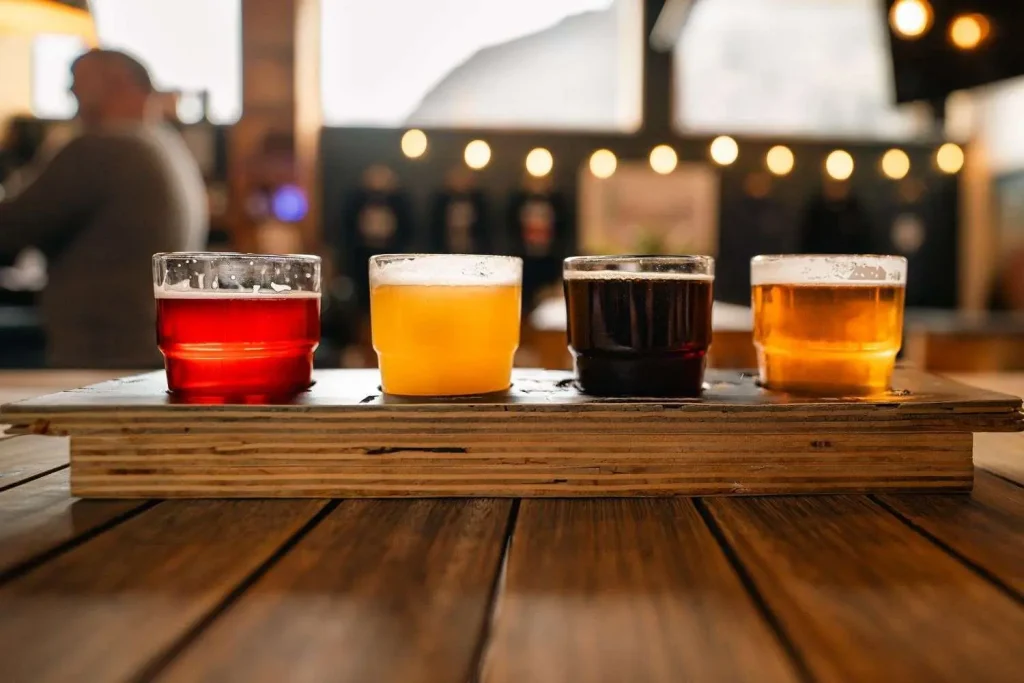 Glasses of craft beer lined up on the wooden bar of a taproom